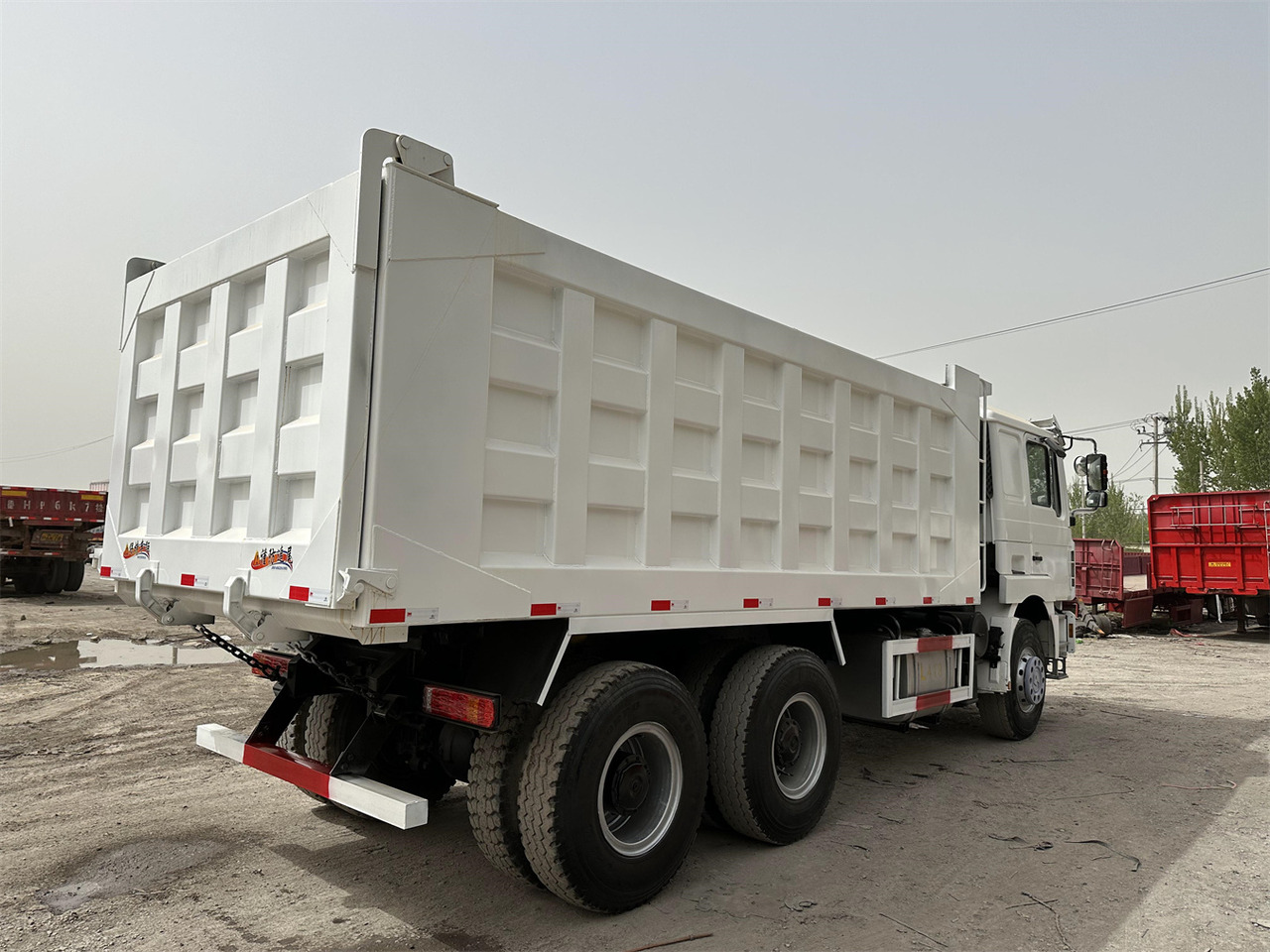 Billenőplatós teherautó a következők szállításához nehézgépek Shacman F3000: 8 kép.