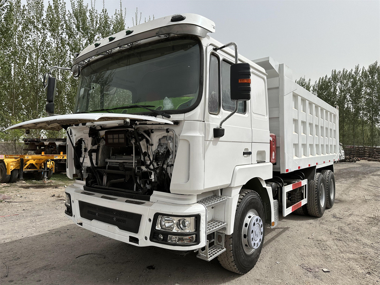 Billenőplatós teherautó a következők szállításához nehézgépek Shacman F3000: 7 kép.