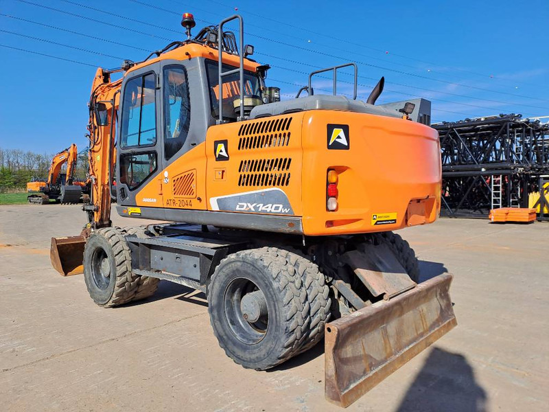 Doosan DX140W-5 - Gumikerekes kotró: 2 kép. Doosan DX140W-5 - Gumikerekes kotró: 2 kép.