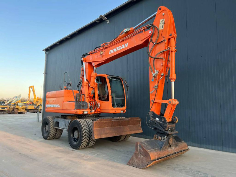 Doosan DX170W - Gumikerekes kotró: 2 kép. Doosan DX170W - Gumikerekes kotró: 2 kép.