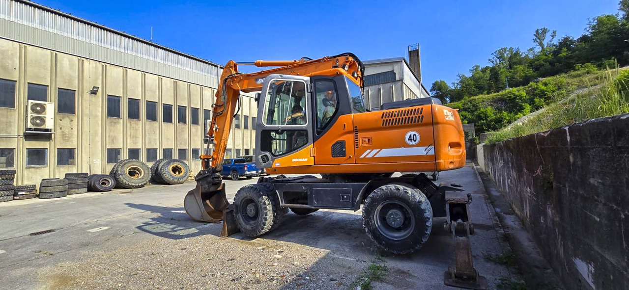 Doosan DX160W - Gumikerekes kotró: 2 kép. Doosan DX160W - Gumikerekes kotró: 2 kép.