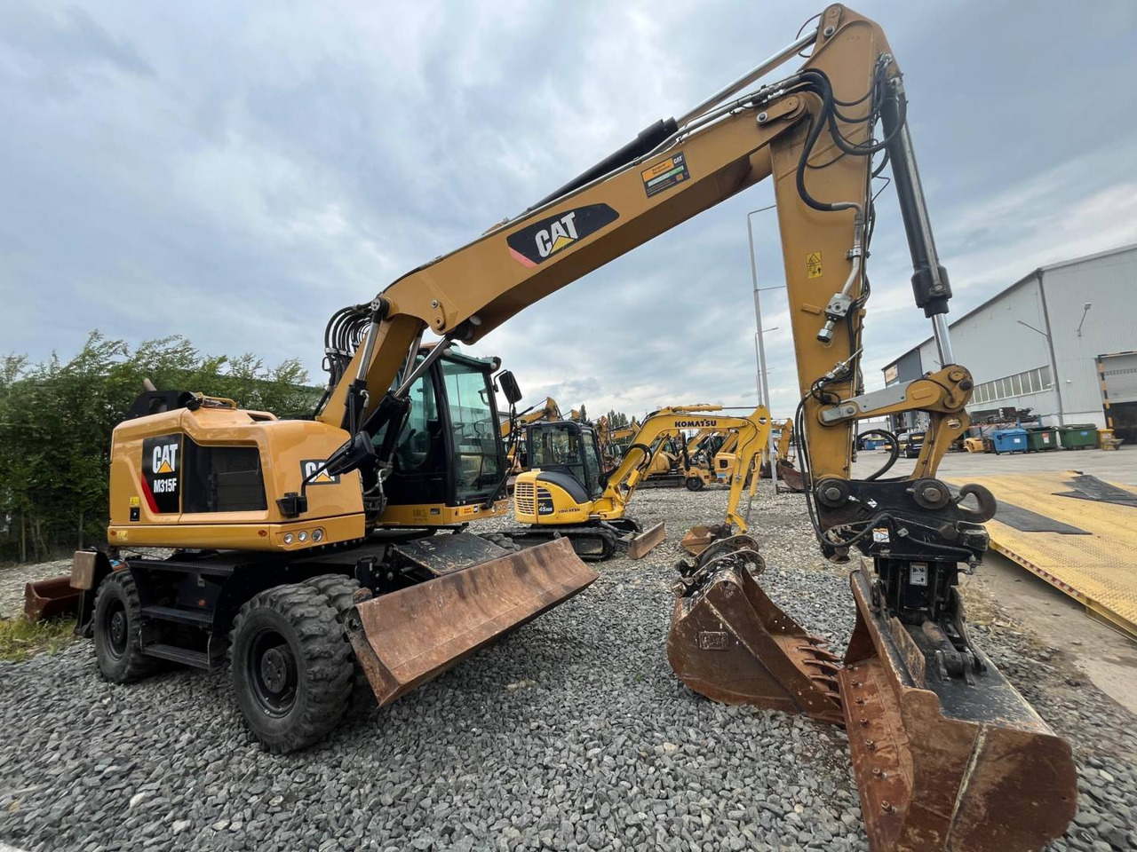 CAT M315F - Gumikerekes kotró: 2 kép. CAT M315F - Gumikerekes kotró: 2 kép.