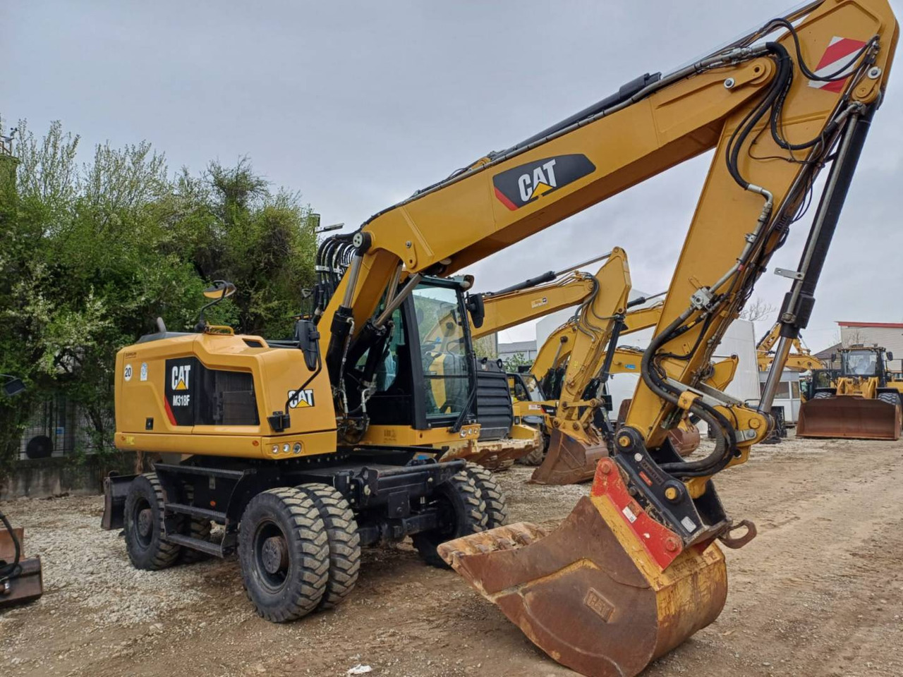 CAT M318F - Gumikerekes kotró: 2 kép. CAT M318F - Gumikerekes kotró: 2 kép.