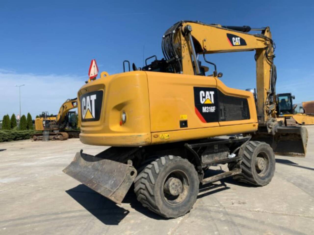 CAT M316F - Gumikerekes kotró: 3 kép. CAT M316F - Gumikerekes kotró: 3 kép.