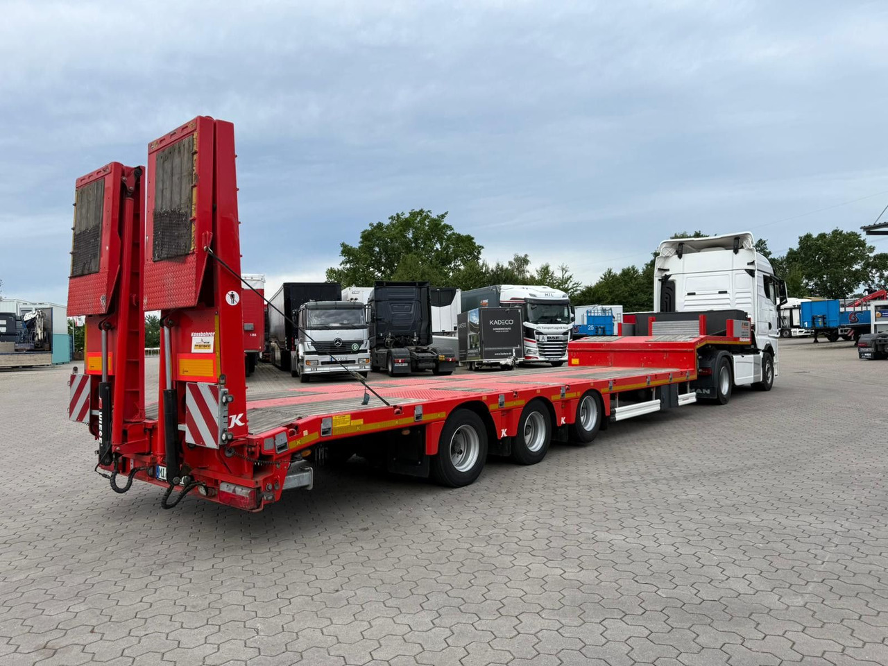 Kässbohrer K.SLS ECO Tieflader mit hydraulischen Rampen - Félpótkocsi mélybölcsős: 2 kép. Kässbohrer K.SLS ECO Tieflader mit hydraulischen Rampen - Félpótkocsi mélybölcsős: 2 kép.