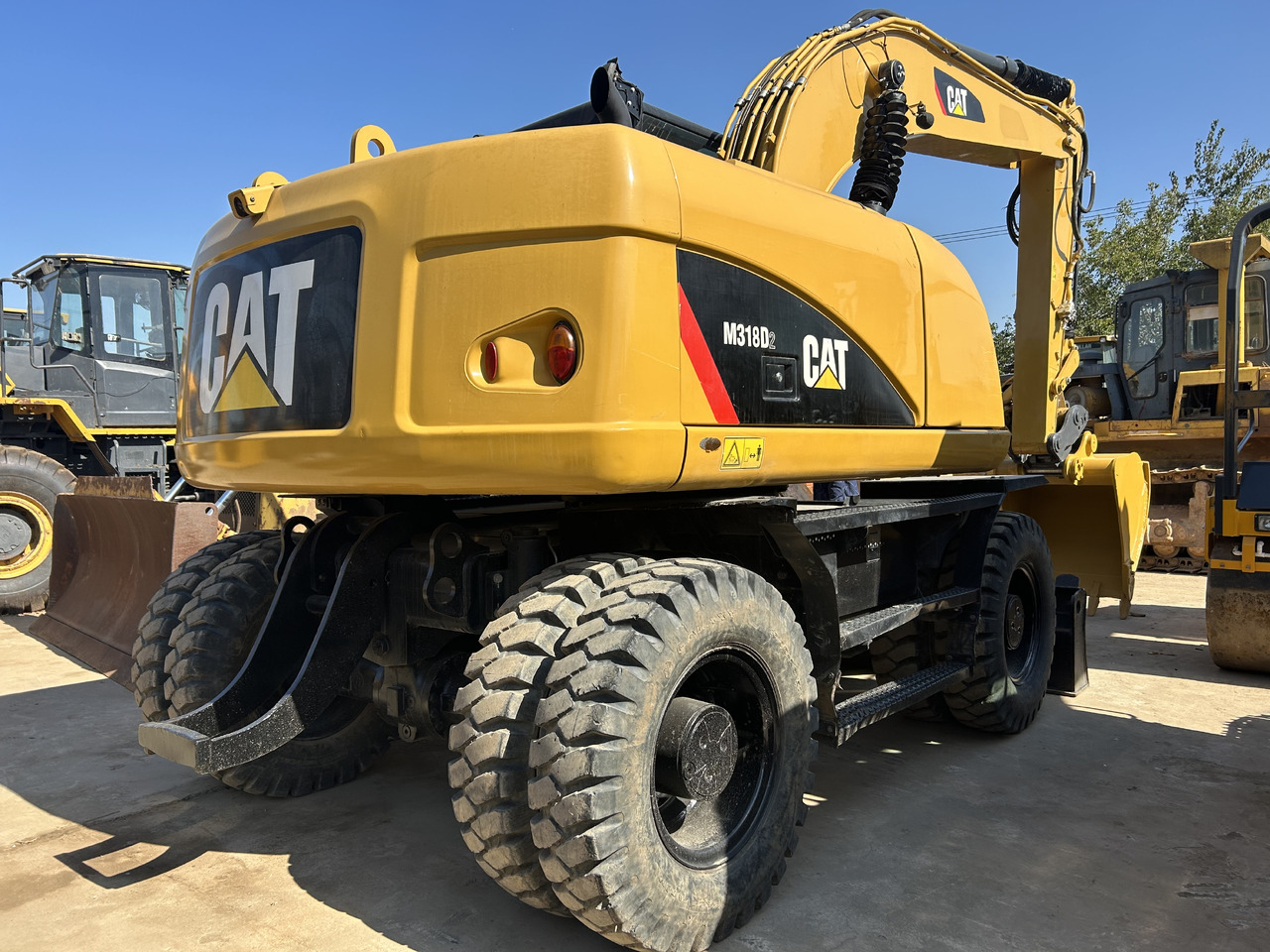 CATERPILLAR M318 - Gumikerekes kotró: 2 kép. CATERPILLAR M318 - Gumikerekes kotró: 2 kép.