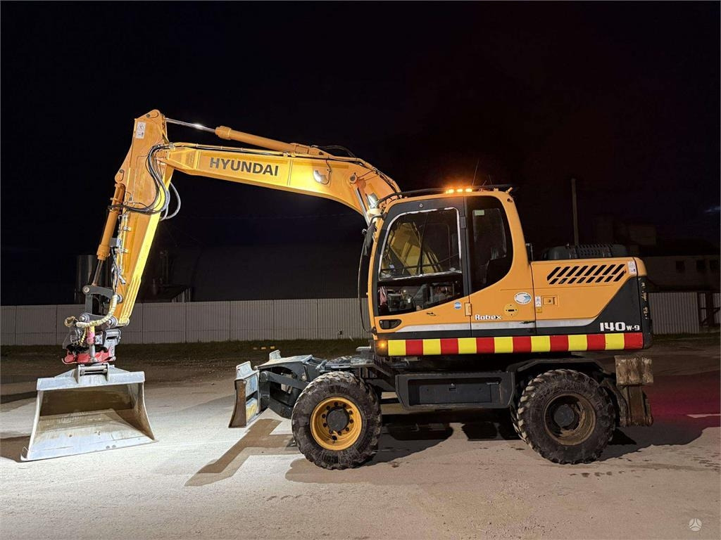 Hyundai Robex 140 W-9 ROTOTILT - Gumikerekes kotró: 2 kép. Hyundai Robex 140 W-9 ROTOTILT - Gumikerekes kotró: 2 kép.