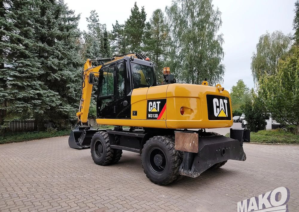Caterpillar M313D - Gumikerekes kotró: 2 kép. Caterpillar M313D - Gumikerekes kotró: 2 kép.