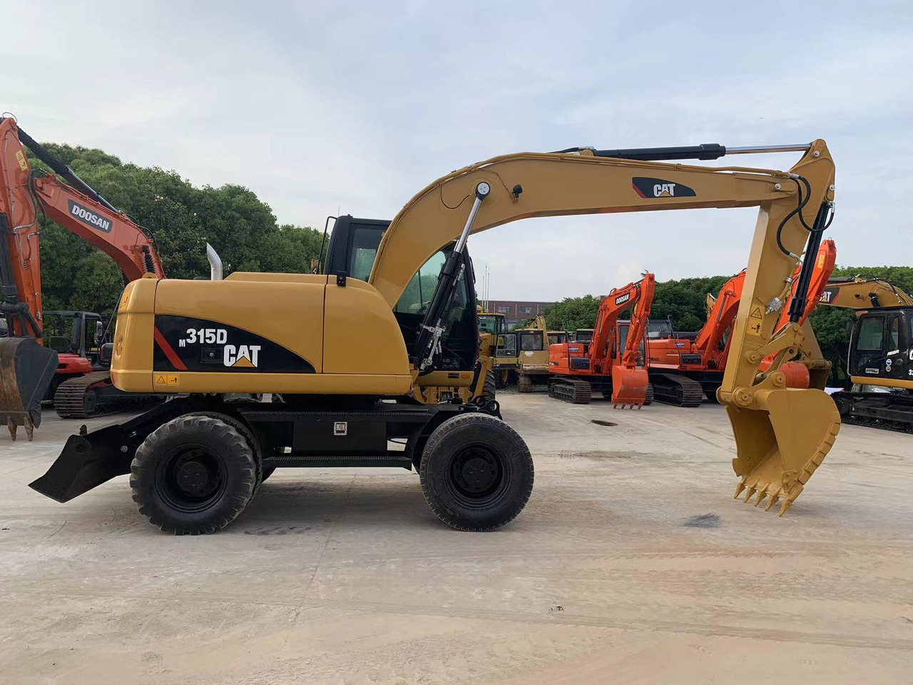 Caterpillar M315D Wheel Excavator Moving by Tires - Gumikerekes kotró: 1 kép. Caterpillar M315D Wheel Excavator Moving by Tires - Gumikerekes kotró: 1 kép.