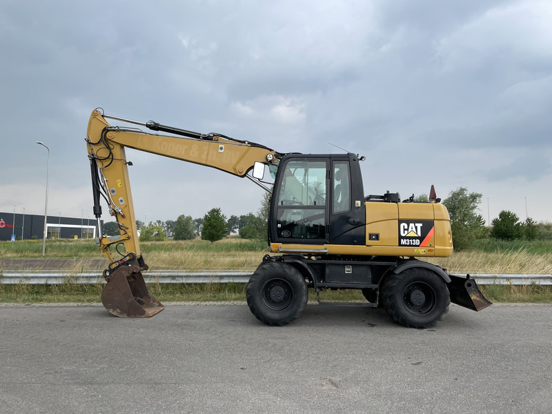 Caterpillar M313D - CE - Gumikerekes kotró: 1 kép. Caterpillar M313D - CE - Gumikerekes kotró: 1 kép.