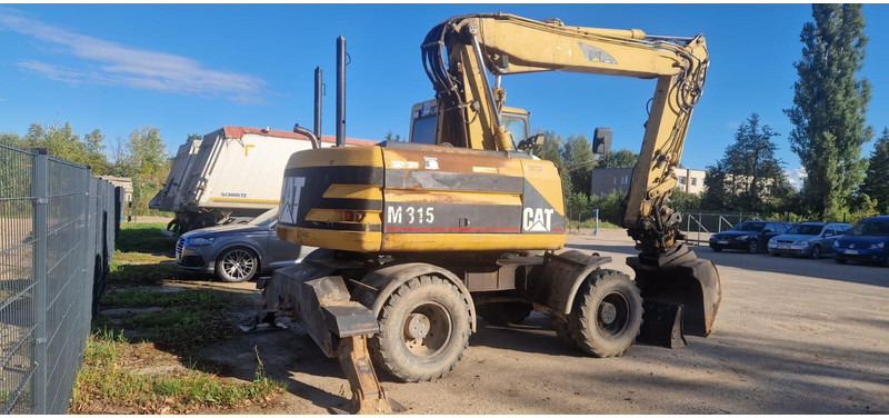 Caterpillar M 315 Rototilt - Gumikerekes kotró: 2 kép. Caterpillar M 315 Rototilt - Gumikerekes kotró: 2 kép.
