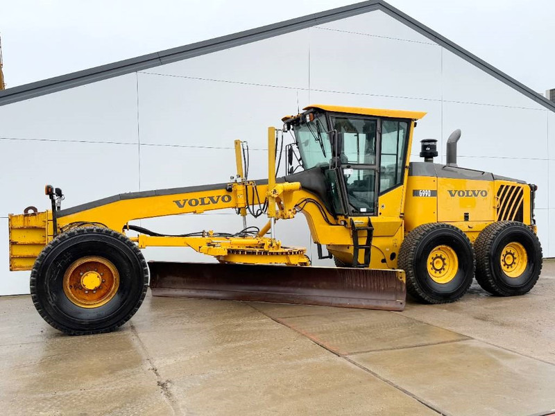 Volvo G990 - 4.85m Blade / Pushblock / Airco - Gréder: 1 kép. Volvo G990 - 4.85m Blade / Pushblock / Airco - Gréder: 1 kép.