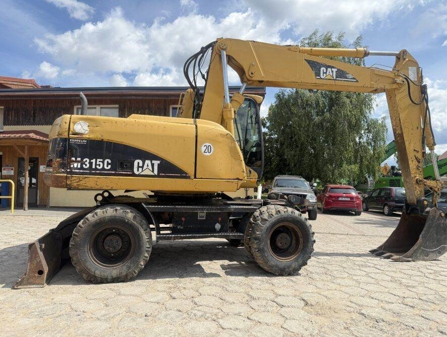 CAT M315C AC - Gumikerekes kotró: 4 kép. CAT M315C AC - Gumikerekes kotró: 4 kép.