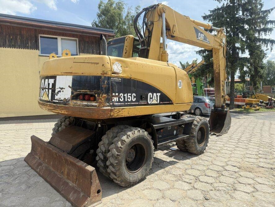 CAT M315C AC - Gumikerekes kotró: 5 kép. CAT M315C AC - Gumikerekes kotró: 5 kép.