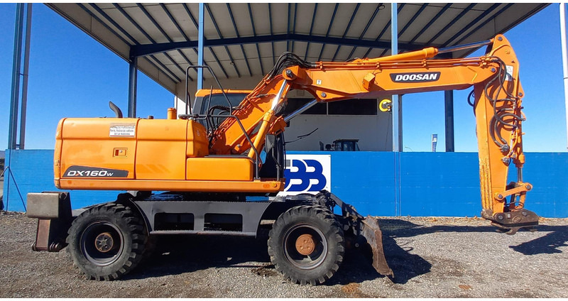 Doosan DX140W-3 - Gumikerekes kotró: 2 kép. Doosan DX140W-3 - Gumikerekes kotró: 2 kép.