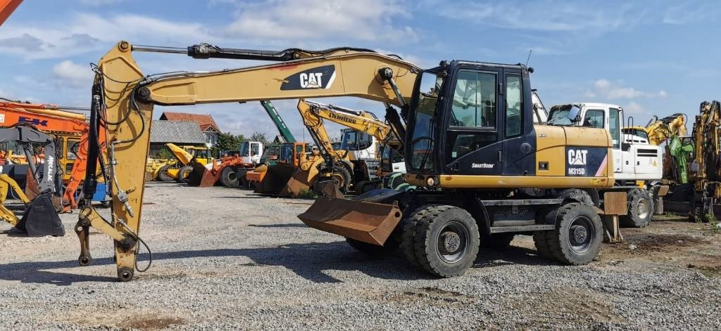 CAT M 315 D - Gumikerekes kotró: 1 kép. CAT M 315 D - Gumikerekes kotró: 1 kép.