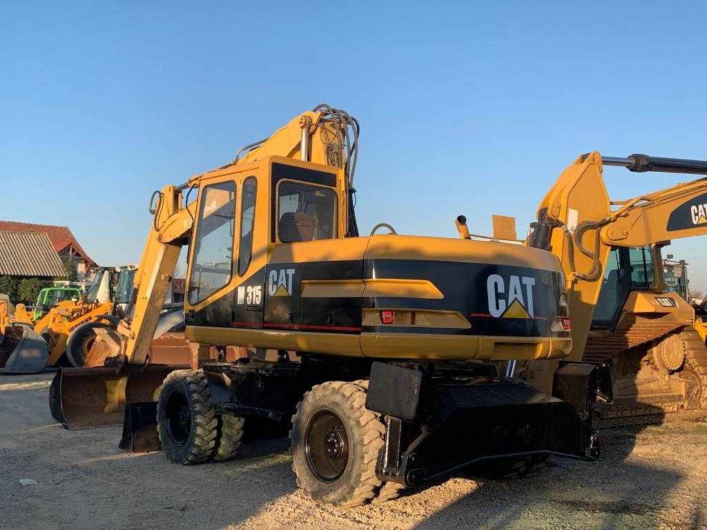 CAT M 315 - Gumikerekes kotró: 4 kép. CAT M 315 - Gumikerekes kotró: 4 kép.