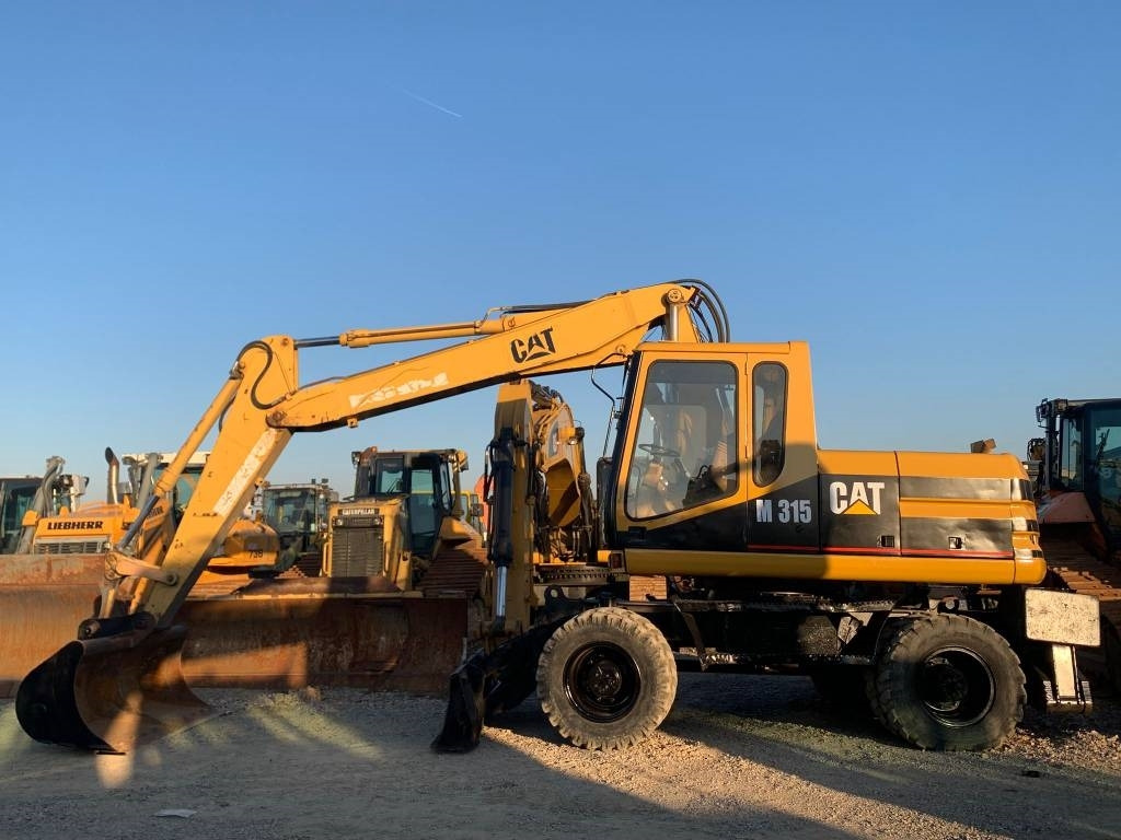 CAT M 315 - Gumikerekes kotró: 3 kép. CAT M 315 - Gumikerekes kotró: 3 kép.