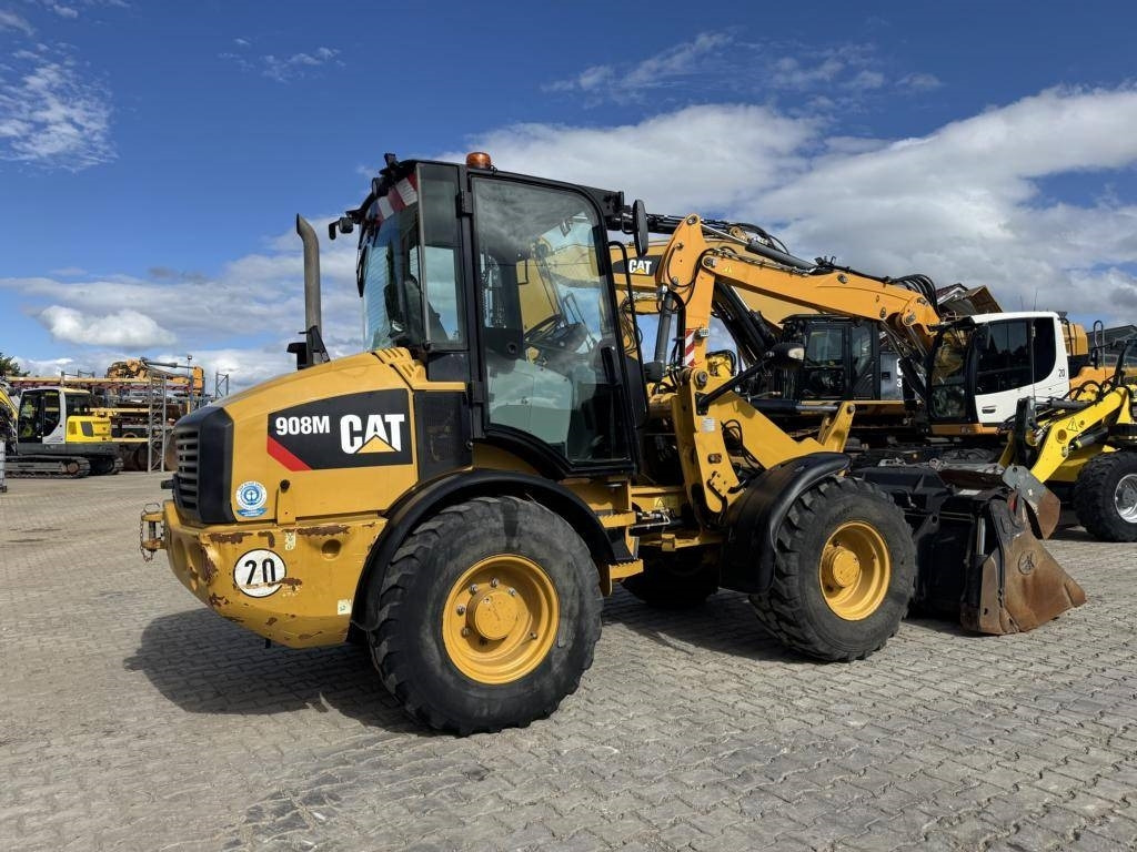 CAT 908M mit Klappschaufe und Palletengabeln - Gumikerekes homlokrakodó: 4 kép. CAT 908M mit Klappschaufe und Palletengabeln - Gumikerekes homlokrakodó: 4 kép.