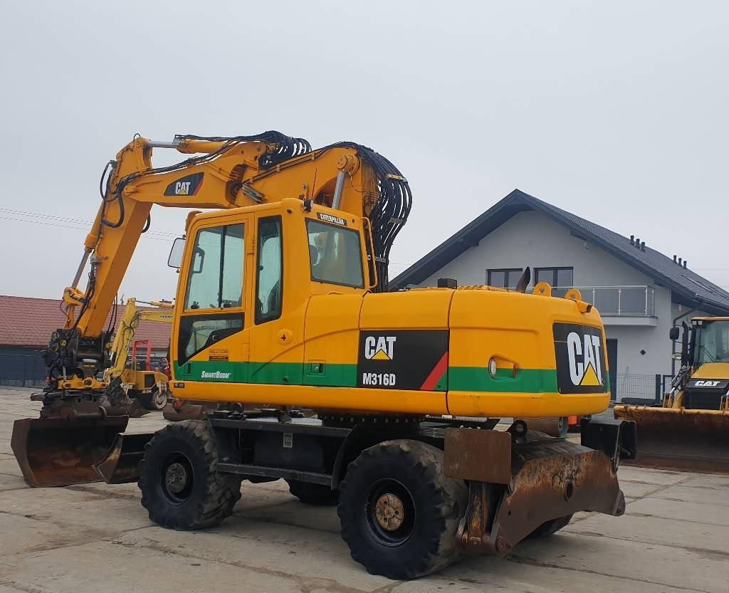 CAT M 316 D - Gumikerekes kotró: 2 kép. CAT M 316 D - Gumikerekes kotró: 2 kép.