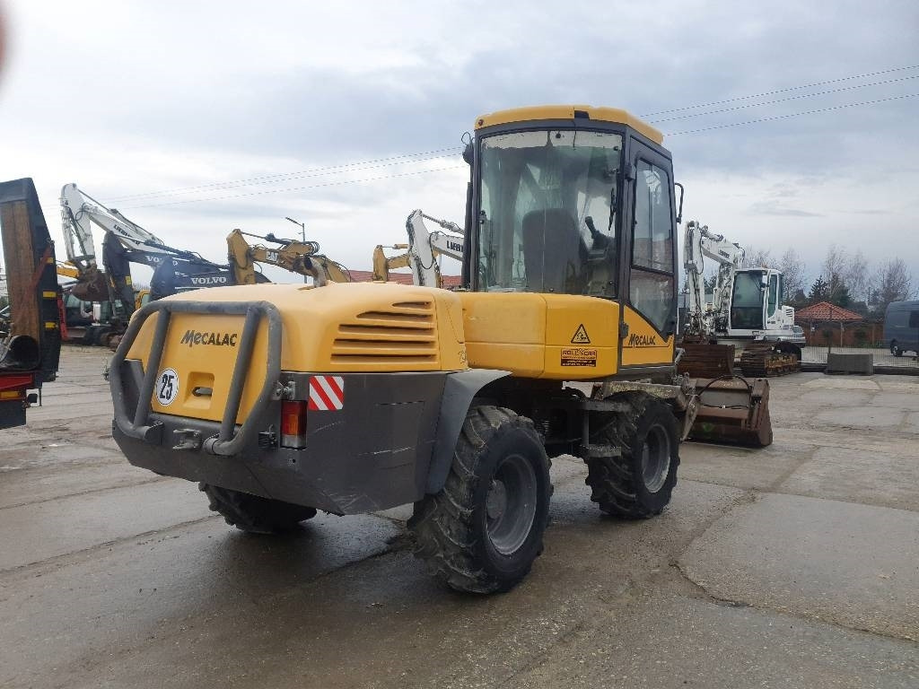 Mecalac 12 M TX - Gumikerekes kotró: 4 kép. Mecalac 12 M TX - Gumikerekes kotró: 4 kép.