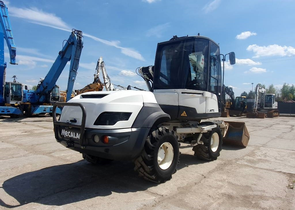 Mecalac 12 M TX - Gumikerekes kotró: 4 kép. Mecalac 12 M TX - Gumikerekes kotró: 4 kép.