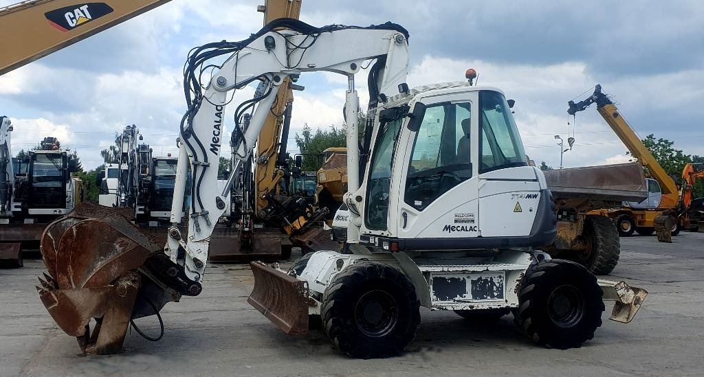 Mecalac 714 MWE - Gumikerekes kotró: 2 kép. Mecalac 714 MWE - Gumikerekes kotró: 2 kép.