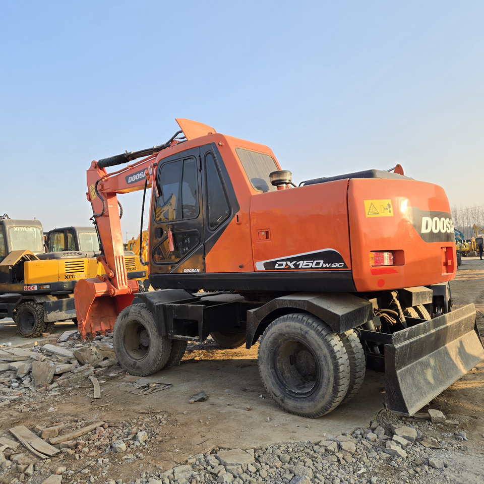 Doosan DX150W-9C - Gumikerekes kotró: 2 kép. Doosan DX150W-9C - Gumikerekes kotró: 2 kép.