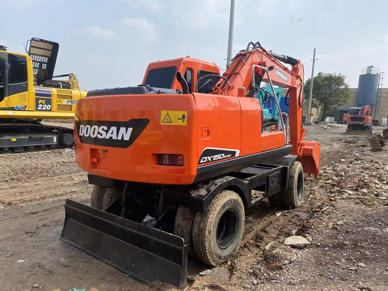 Doosan DX150W - Gumikerekes kotró: 2 kép. Doosan DX150W - Gumikerekes kotró: 2 kép.