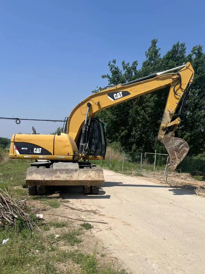 CATERPILLAR M317 - Gumikerekes kotró: 1 kép. CATERPILLAR M317 - Gumikerekes kotró: 1 kép.