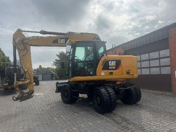 CAT M318F - Gumikerekes kotró: 2 kép. CAT M318F - Gumikerekes kotró: 2 kép.