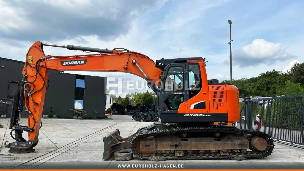 Doosan Kettenbagger DX 235 LCR-5, hyd. SW OilQuick 70-55 - Lánctalpas kotró: 3 kép. Doosan Kettenbagger DX 235 LCR-5, hyd. SW OilQuick 70-55 - Lánctalpas kotró: 3 kép.