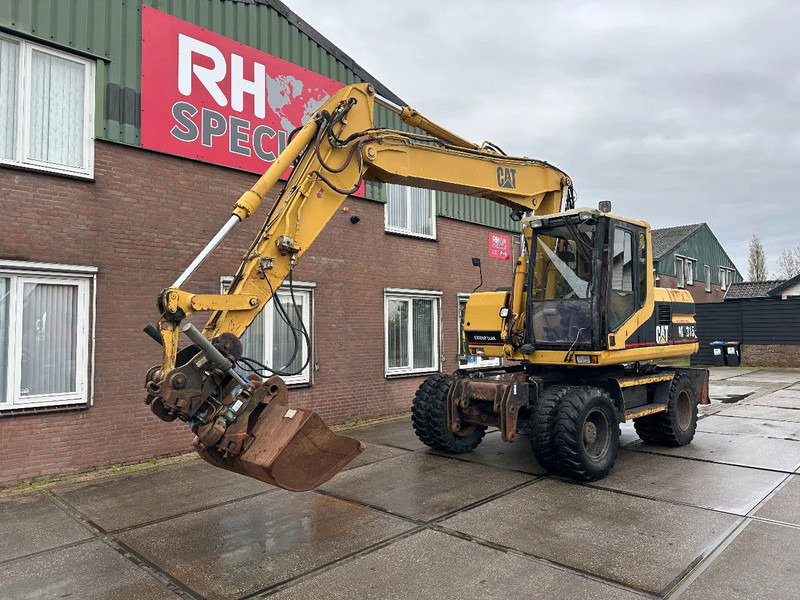 Caterpillar M315 +ROTO CE - Gumikerekes kotró: 2 kép. Caterpillar M315 +ROTO CE - Gumikerekes kotró: 2 kép.