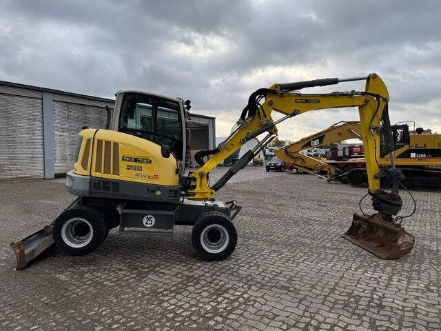 Neuson EW65, Verstellausleger, Hydr. S.W.S.,Div. Löffel - Gumikerekes kotró: 5 kép. Neuson EW65, Verstellausleger, Hydr. S.W.S.,Div. Löffel - Gumikerekes kotró: 5 kép.