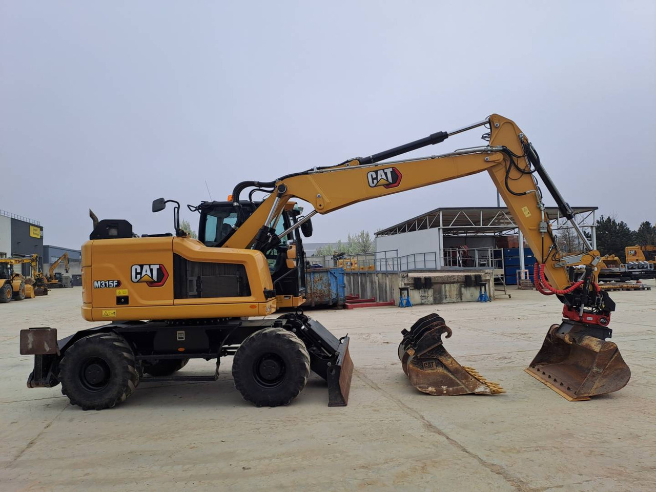 CAT M315F IVC - Gumikerekes kotró: 5 kép. CAT M315F IVC - Gumikerekes kotró: 5 kép.