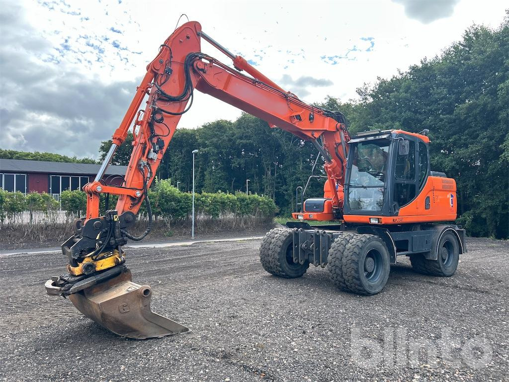 Doosan DX160W - Gumikerekes kotró: 2 kép. Doosan DX160W - Gumikerekes kotró: 2 kép.