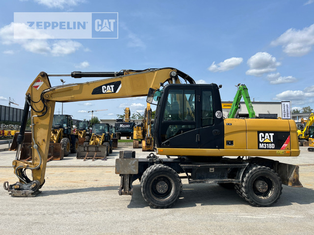 Cat M318D - Gumikerekes kotró: 3 kép. Cat M318D - Gumikerekes kotró: 3 kép.